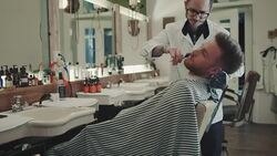 Barber cutting beard Stock Footage