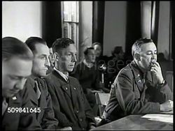 1945: MILITARY TRIBUNAL: INT WS Crowded courtroom, Dachau. MS Accused German Nazi officer Franz Strasser sitting at table. MS U.S. Military Commission (judge, jury). MS Strasser & interpreter at table, interpreter standing to take oath. (SOT) Trial Instructional Video