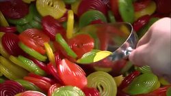 A scoop scoops multicolored candies out of a bin. Stock Footage