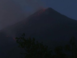 Lava tumbles down the side of erupting volcano at dusk, Philippines, Dec 2009 Stock Footage
