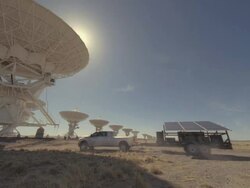 WS ZO Truck pulling solar panel near satellites dishes on sunny day / San Augustine, New Mexico, USA  Stock Footage