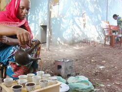 Ethiopian woman pouring coffee into cups Stock Footage