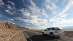 A car on the road near Badwater which is the lowest point in the USA being 282 feet below sea level in Death Valley. Death Valley is the lowest, hottest, driest place in the USA, with an average annual rainfall of around 2 inches, some years it does not re Stock Footage