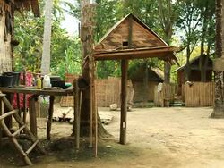 MS SLO MO Shot of Wooden primitive looking structures with woman passing by / Muang Ngoi, Luang Prabang, Laos Stock Footage