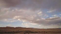 Clouds move over the Atlas mountains near the ancient Kasbah town of Ait Benhaddou, Morocco. Stock Footage