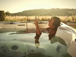 Woman in thermal bath watching movie on digital tablet Stock Footage