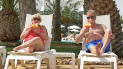 Video of senior couple drinking cocktails on sunbeds in 4K Stock Footage
