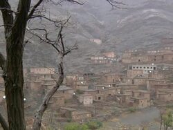 WS View of tree with homes built into base of atlas mountains in rain / Marrakech, Tensift, Morocco  Stock Footage