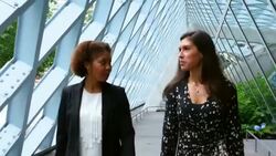 MS TS Two smiling businesswomen in discussion while walking down corridor outside of office building Stock Footage