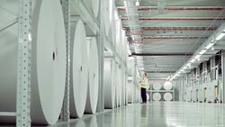 Businessman checking large paper rolls in paper mill Stock Footage