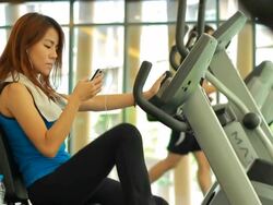 Woman using smart phone at gym Stock Footage