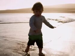 Child walking on beach Stock Footage