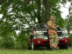 Fireman rests by leaning on his truck Stock Footage