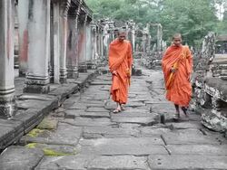 Cambodian monks walking at Bayon exterior Stock Footage