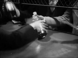 B/W 1933 close up men's hands paying for bottles of liquor + putting them in paper bags Stock Footage