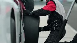 Pit-crew replaces race-car tire and tightens lug-nuts Stock Footage