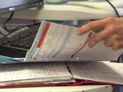 Doctor reading folder on ward News Clip