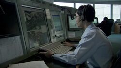 A shipping lane controller monitors several displays. Stock Footage