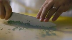 Skilled chef mince cuts parsley on kitchen table in restaurant Stock Footage