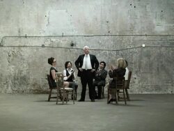 Businessman standing in circle of chairs, colleagues clapping Stock Footage