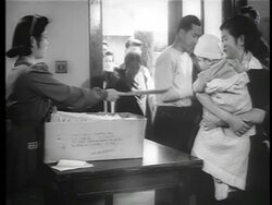 B/W 1942/3 Japanese-American woman handing families entering building paperwork / internment camps Stock Footage