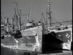 1942: NAVAL BASE DEPOT: HA WS EXT Naval Depot. Supply ships in dock. Sign: 'US Naval Base Depot' WS Shipping lot filled w/ trucks, ambulances. MS Row of trucks. WS Rows of ship anchors. Large stack of prefabricated pontoons. WWII Instructional Video