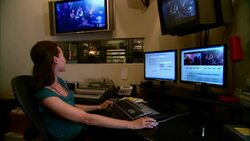 MS PAN Female editor working at computer in studio and communicating with colleague through window/ New York, New York Stock Footage