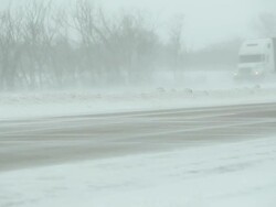 Winter Blizzard with Blowing Snow Across Highway and Vehicles Stock Footage