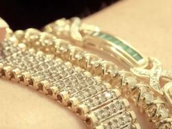 CU three diamond studded bracelets on female arm as hand pulls one bracelet across /  Los Angeles, California, USA  Stock Footage