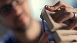 Young woodworker concentrates on chiseling details in intricate frame Stock Footage