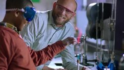 Teacher supervises a student using Bunsen burner Stock Footage