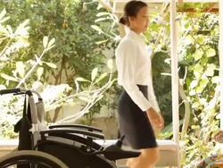 Young caregiver helping elderly woman on wheelchair Stock Footage