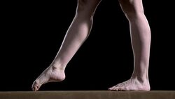 SLO MO Legs of gymnast doing cartwheel on balance beam Stock Footage
