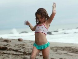 MS TS Little girl doing dance moves on beach then does cartwheels / Montezuma, Puntarenas, Costa Rica Stock Footage