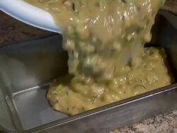 Filling baking pan with zucchini bread dough Stock Footage