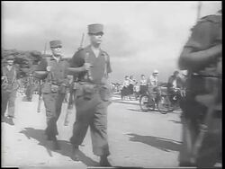 B/W 1962 Cuban soldiers in uniforms carrying guns marching past camera / Cuban Missile Crisis Stock Footage