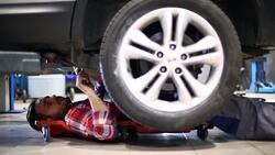 Car mechanic working under a vehicle. Stock Footage