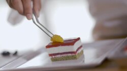 Pastry chef decorates raspberry cake with tangerine slices Stock Footage
