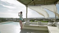 Woman photographing view on luxury patio overlooking ocean Stock Footage