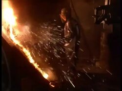 MS Steel worker stoking furnace in factory Stock Footage