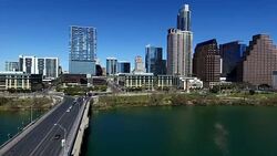 Over Town Lake Austin Texas with a long perspective down 1st avenue bridge with the Austin Skyline 2016 with a deep blue sky Stock Footage