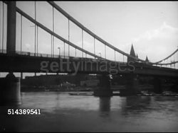 1952: ALLIED-OCCUPIED VIENNA: HA WS Line of boats docked along Danube River, Angled WS Bridge over Danube River, VS People sitting in park gazebo & open air cafes, eating desserts, drinking, waiting, socializing. Instructional Video