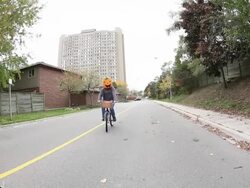 WS PAN Residential street in with man riding bike and wearing halloween pumpkin mask with kids on bike / Toronto, Ontario, Canada Stock Footage