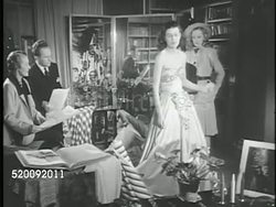1947: PARIS, FRANCE: FRENCH FASHION: **LA TU MS 'Jeanne Lanvin' sign on building, designers female & male for Lanvin fashion house examining elegant strapless dress on model, removing cape, checking bodice & below waist embellishments. Instructional Video