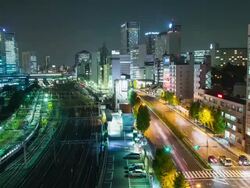 WS T/L View of train and car traffic at shinagawa station at night / Tokyo, Japan Stock Footage