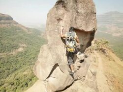 Young man climbing a cliff of mountain  Stock Footage