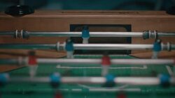 Guys playing tabletop soccer in apartment Stock Footage