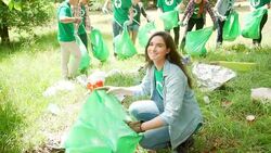 Portrait of smiling environmentalist volunteer picking up trash Stock Footage