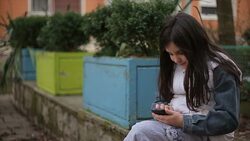 Little girl with mobile phone typing sms Stock Footage