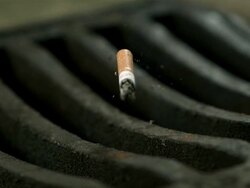 High Speed Cigarette falling in to drain, close up Stock Footage